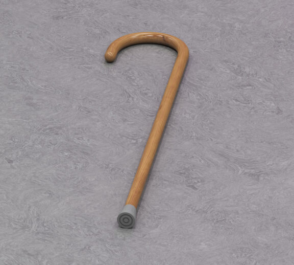 A walking stick lays on grey background