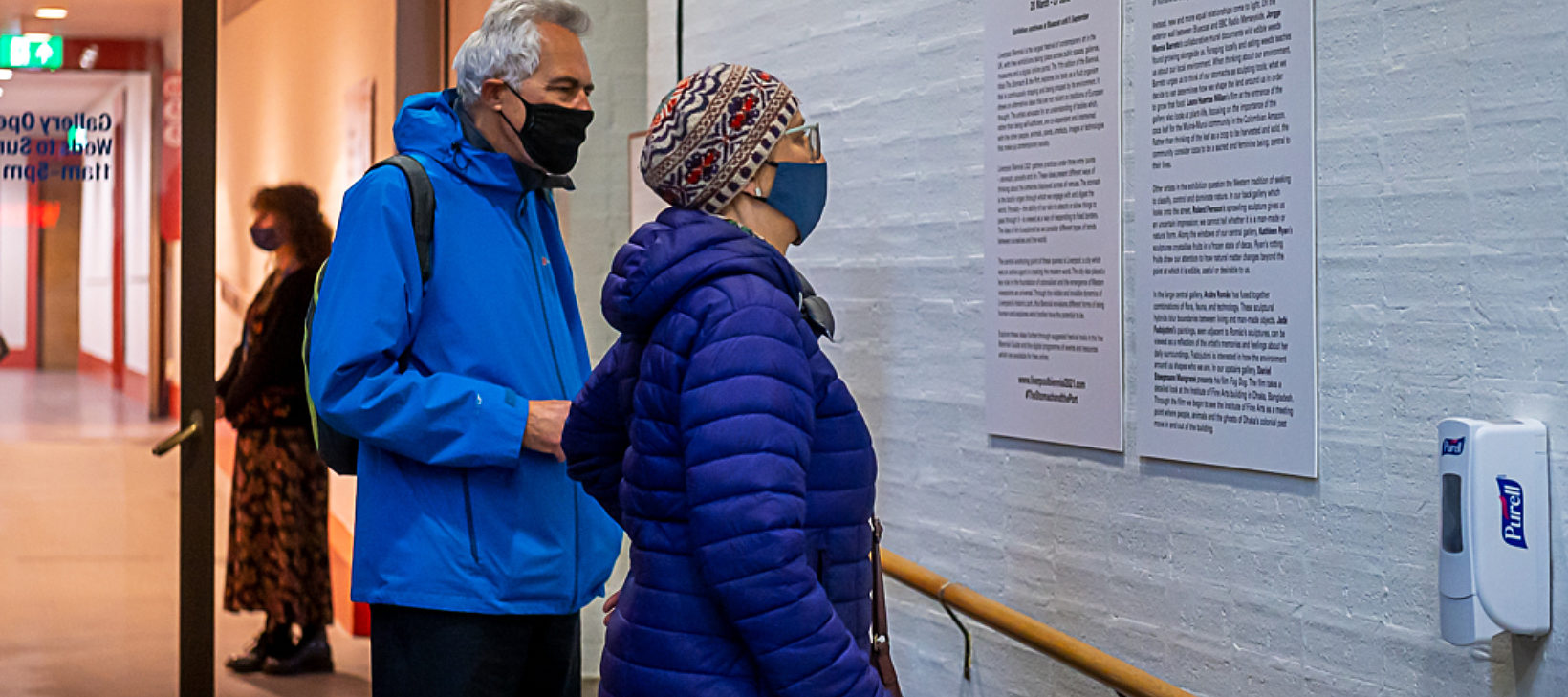 Two customers wearing masks reading Biennial introduction