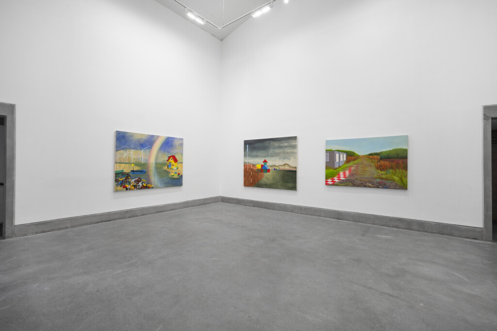 A photograph of the inside of Josie Jenkins' exhibition, Assembled Worlds. The photo shows three landscape paintings.