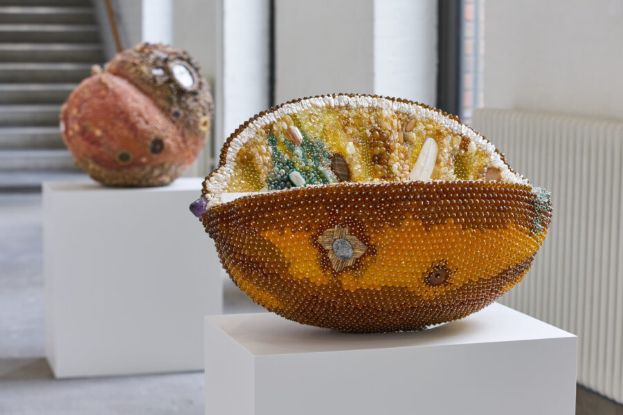 A large sculptural work depicting a rotting lemon, made out of many semi-precious stones.