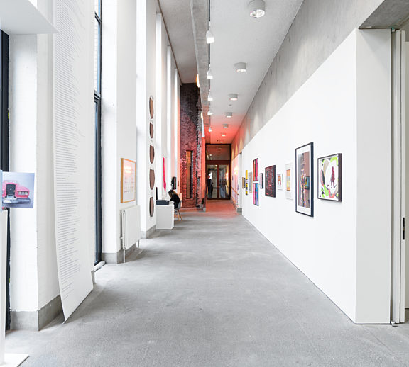 Inside Bluecoat's gallery, there are different artworks along the wall, at the end of the corridor is a red light.