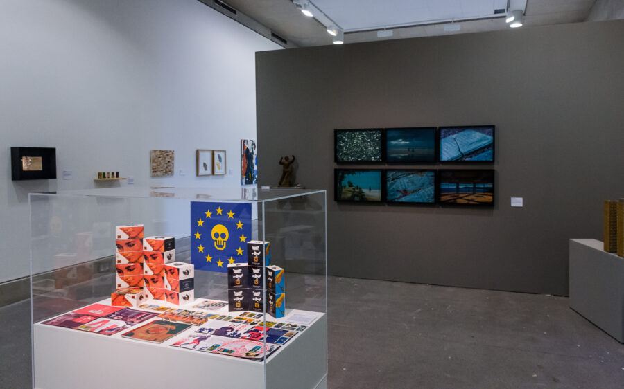 Public View (2017): South Atlantic Souvenirs & Trouble, 'The Trophy Cabinet', reworked from Trophies of Empire (1992), with photographic work by John Akomfrah behind.
