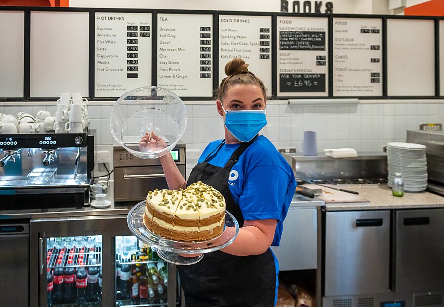 Bluecoat cafe staff holding cake