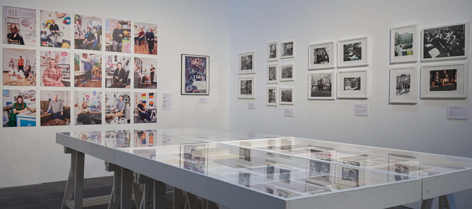 A photograph showing the Bluecoat's archival exhibition, A Creative Community. There are many images and archival materials on the wall, as well as a large display case showcasing more work.