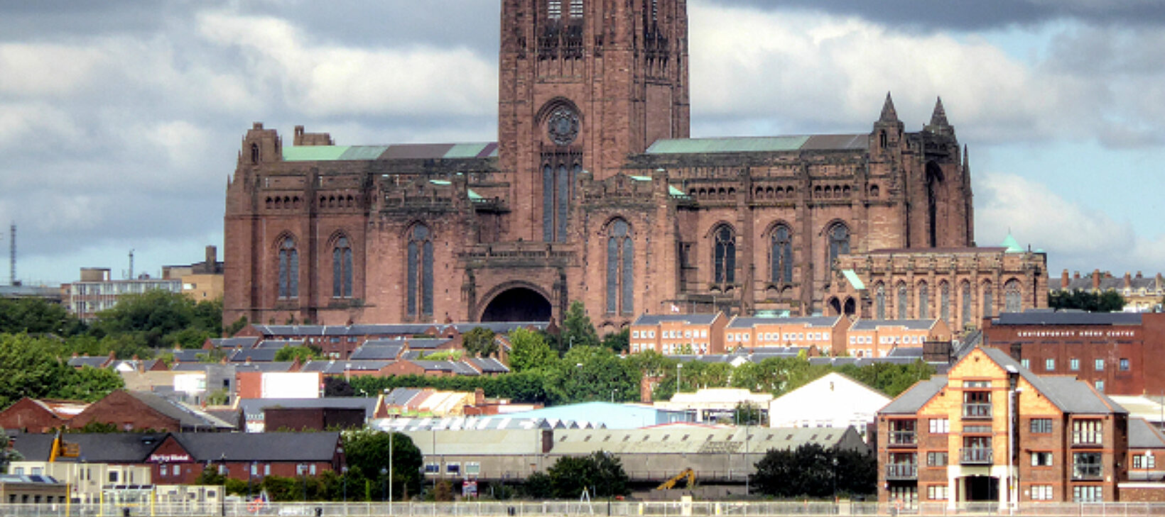 A photograph of a very large cathedral, with stormy skies in the background.