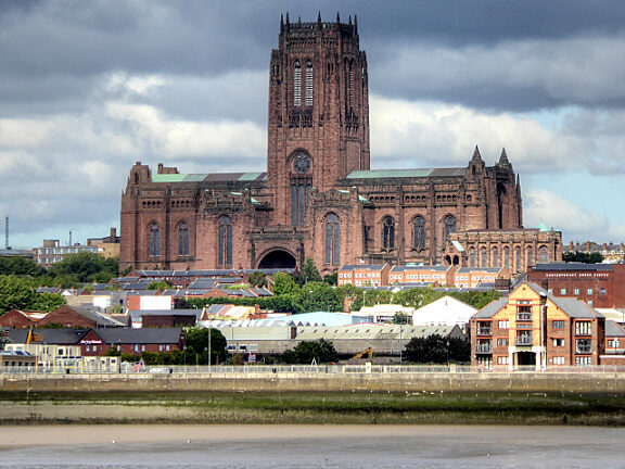 A photograph of a very large cathedral, with stormy skies in the background.