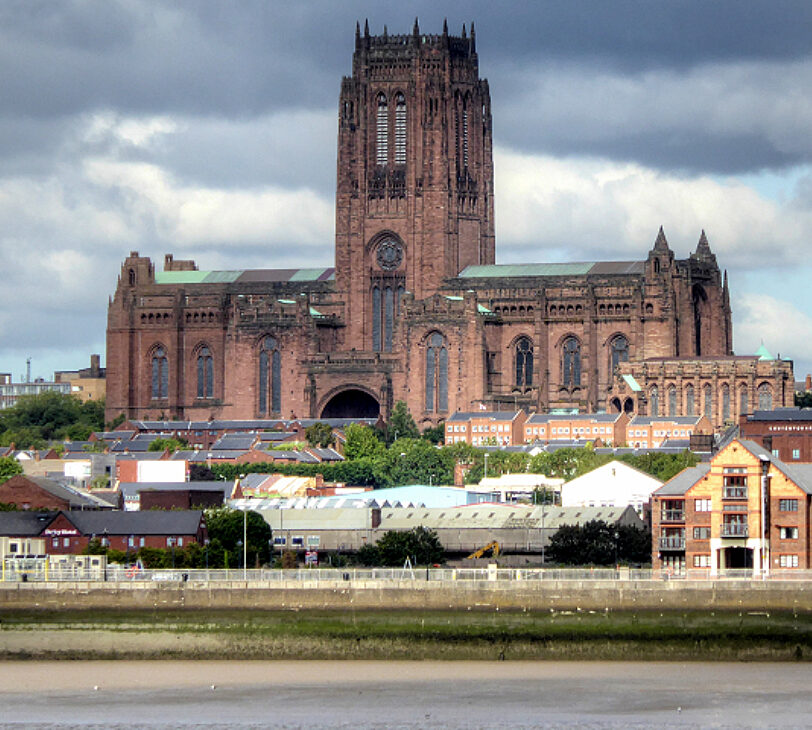 A photograph of a very large cathedral, with stormy skies in the background.